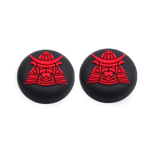 Two black joystick caps with red samurai warrior design on a white background