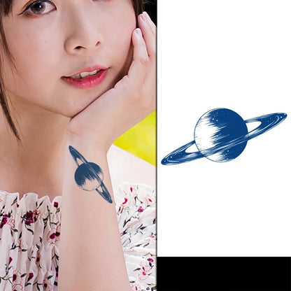 Close-up of a person with a planet-shaped tattoo on their arm