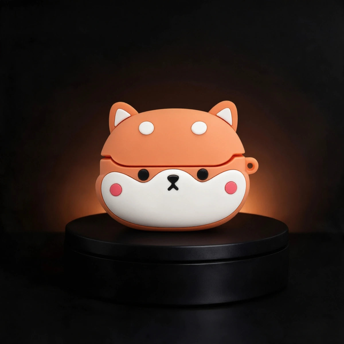 A cute Shiba Inu dog-face wireless earbud case made of silicone, sitting on a black circular display pedestal against a dark background.
