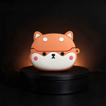 A cute Shiba Inu dog-face wireless earbud case made of silicone, sitting on a black circular display pedestal against a dark background.