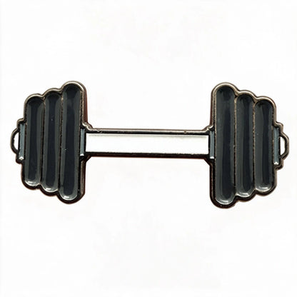 A novelty lapel pin shaped like a dumbbell, featuring a silver-tone metal outline with black enamel fill on the weight plates and handlebar, set against a plain white background.