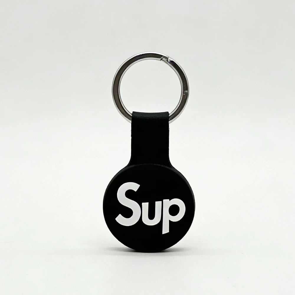 Black keychain with 'Sup' text on a white background