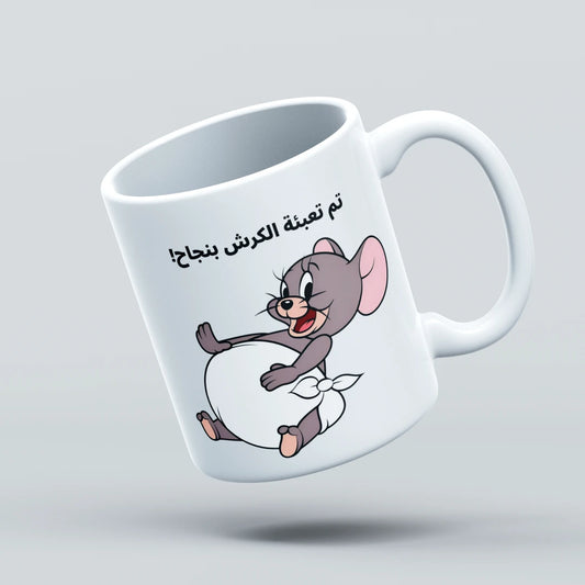 White mug with cartoon character and Arabic text on a light gray background