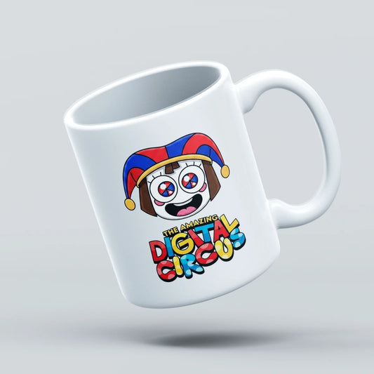A white ceramic coffee mug with a colorful cartoon jester face and the text 'The Amazing Digital Circus' printed on it, shown floating against a light gray background.