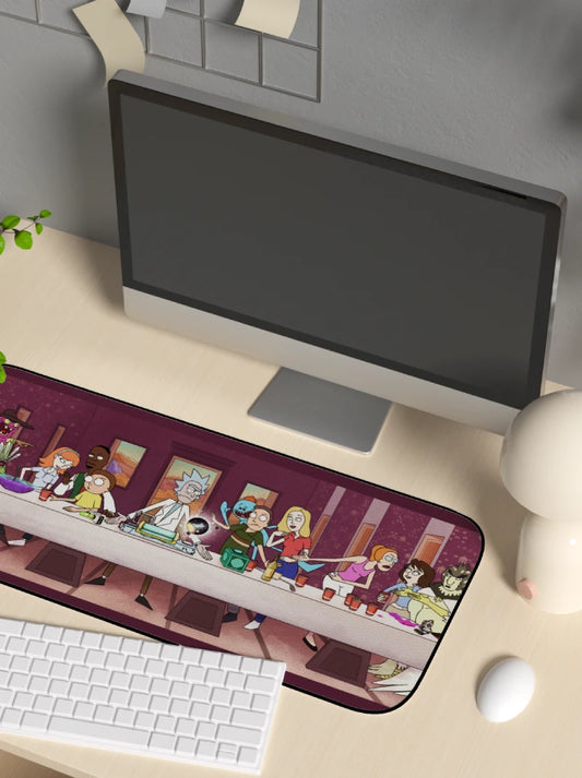 Desk setup with a computer monitor and keyboard on a desk mat featuring cartoon rick and morty characters referencing the last supper.
