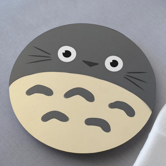 Circular coaster with a cartoon character face on a gray background