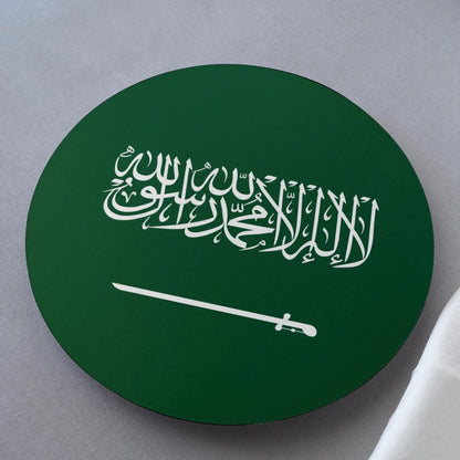 Circular object with white Arabic calligraphy and sword on a green background